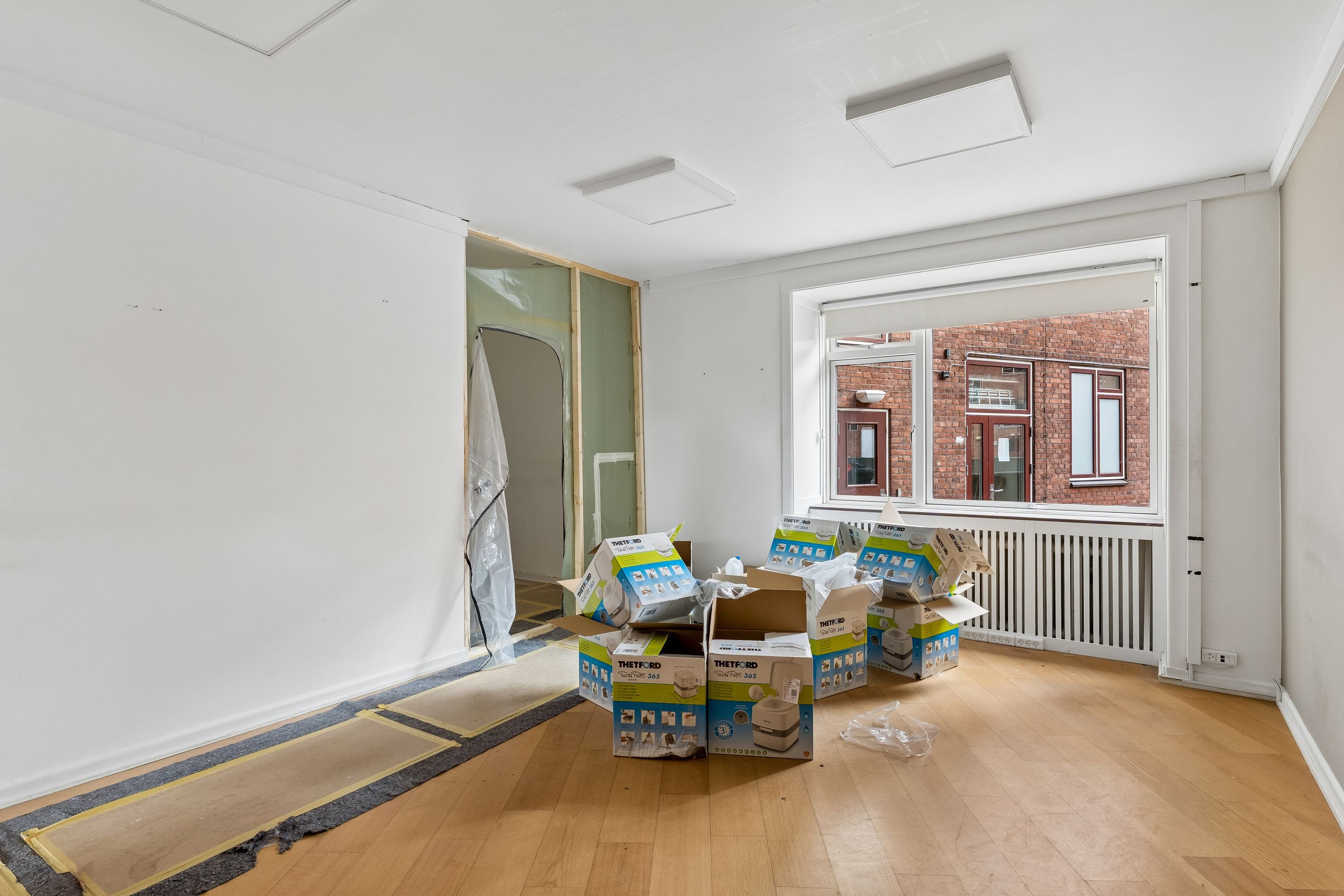 Tomme kasser og nye gulvbelægninger på gulvet i et lejlighedshus i København V, der er i gang med renovering og nyindflytning