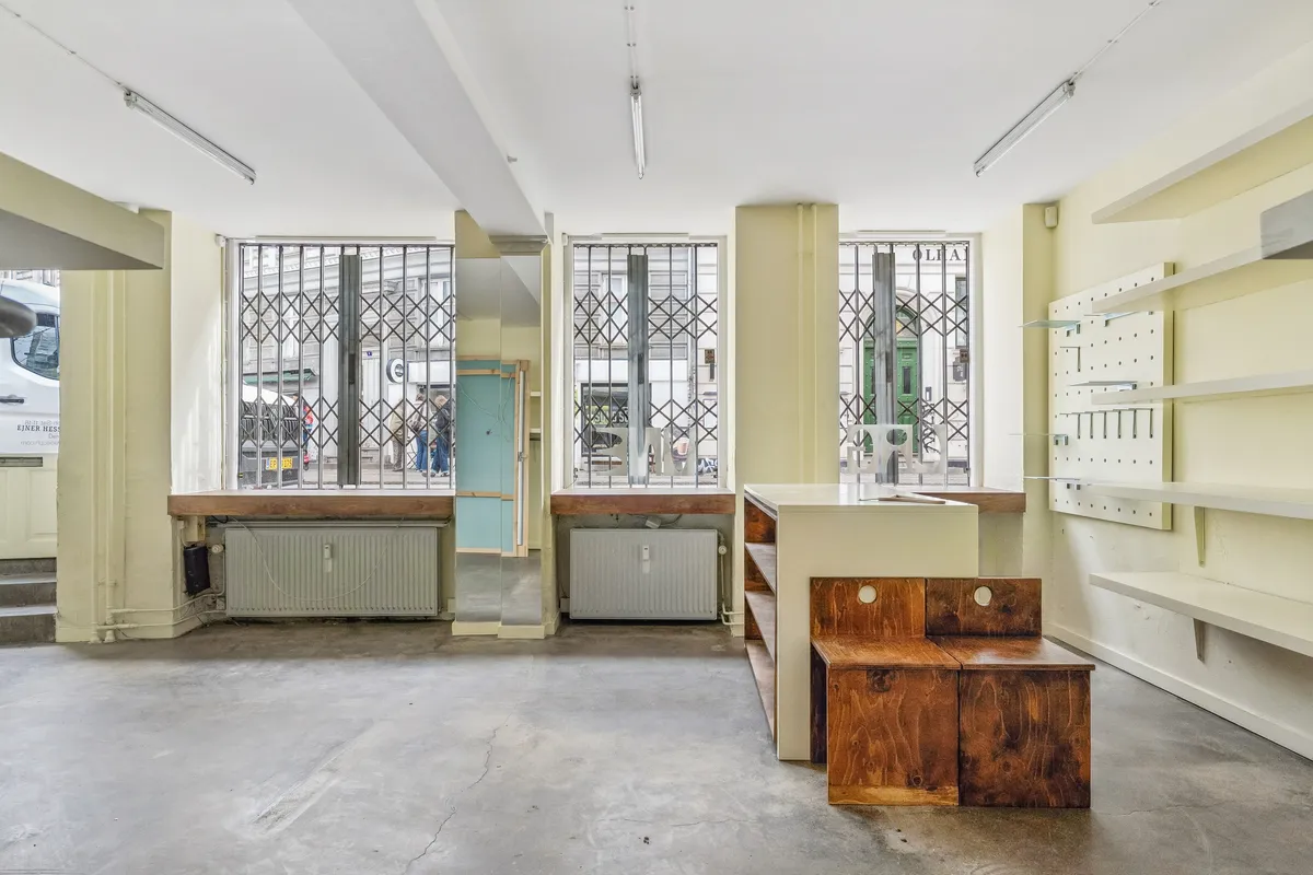 Åben værksted med vinduer, lysekroner og radiatorer i en hjørnelejlighed på Birkegade 1, København N.