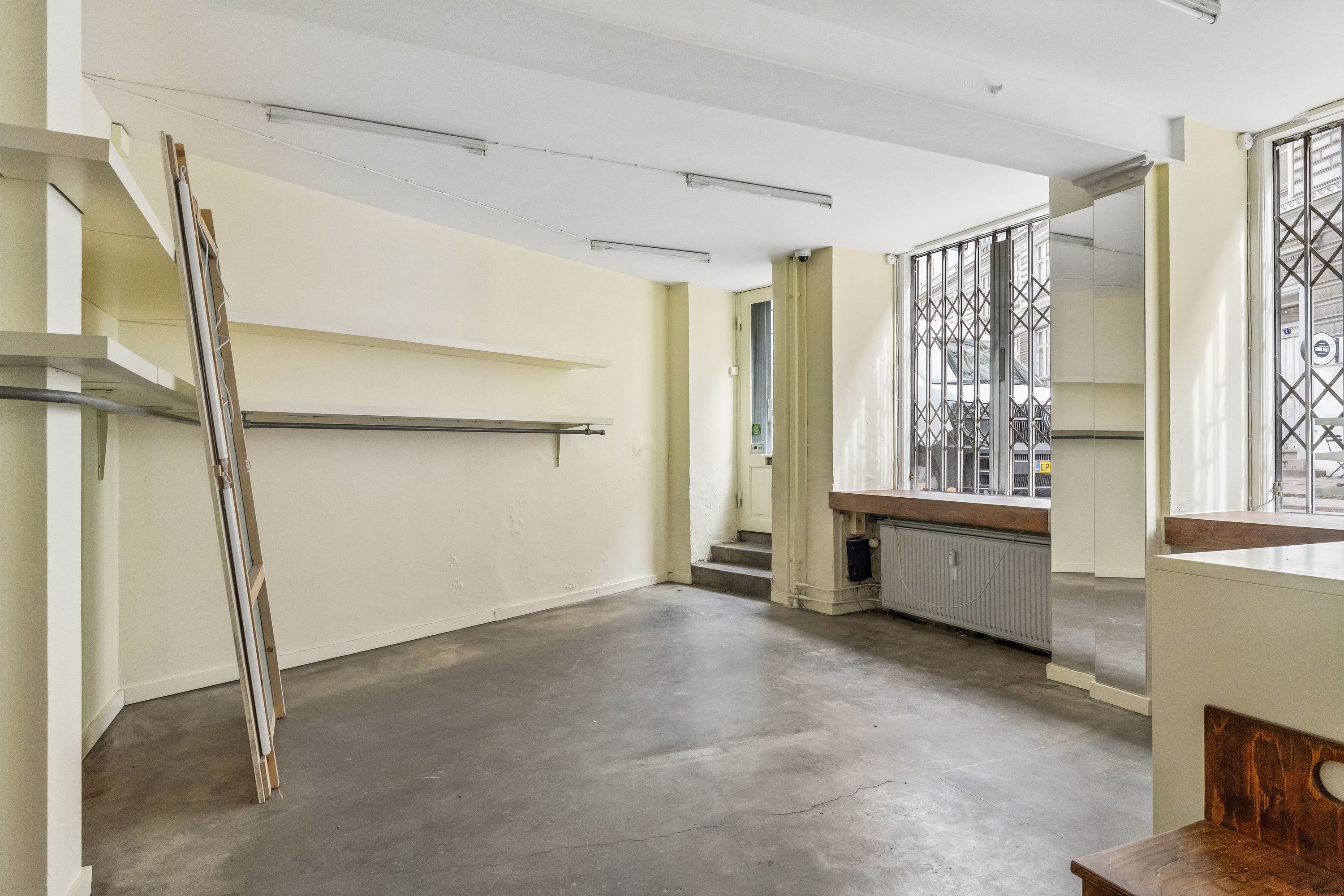 Lejlighedslokaler med lager og kontorlokaler i Birkegade. Der er trætrapper, store ruder, gulve og lofter af beton.