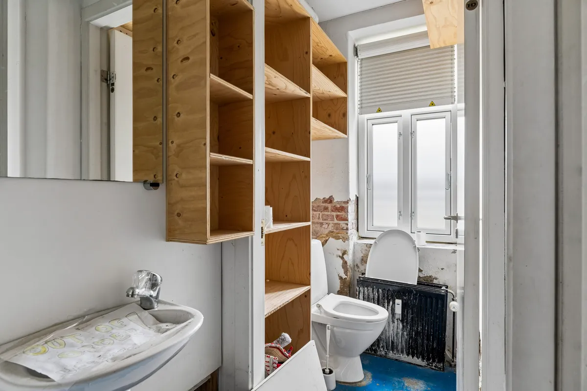 Renoveret toilet i erhvervslejemål med lysevindue og moderne tøjskab og to toiletter i Nørrebro