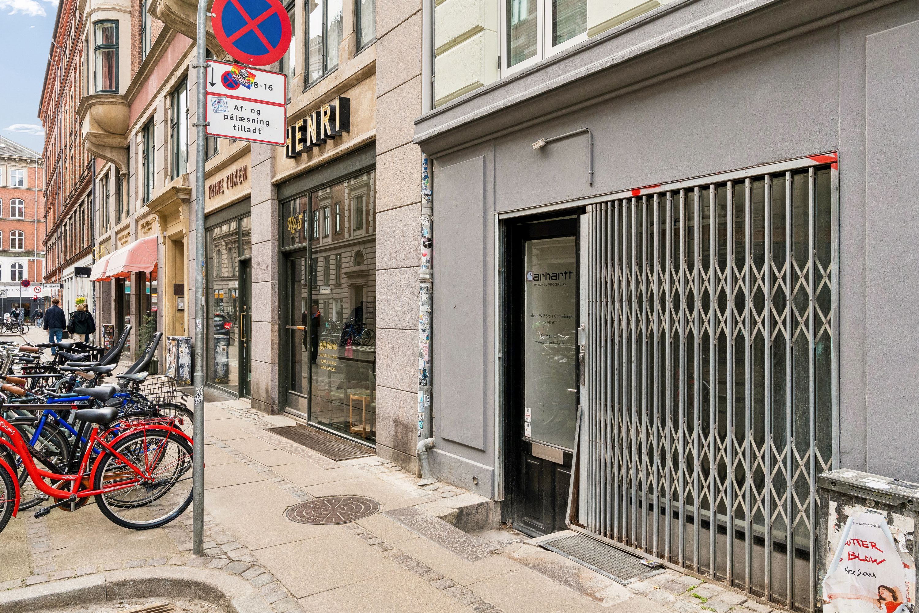 Gade med cykelstativer og åbne butiksdøre i København. Strøget er i Nørrebro og er kendt for sit levende handelsmiljø med trendy butikker.