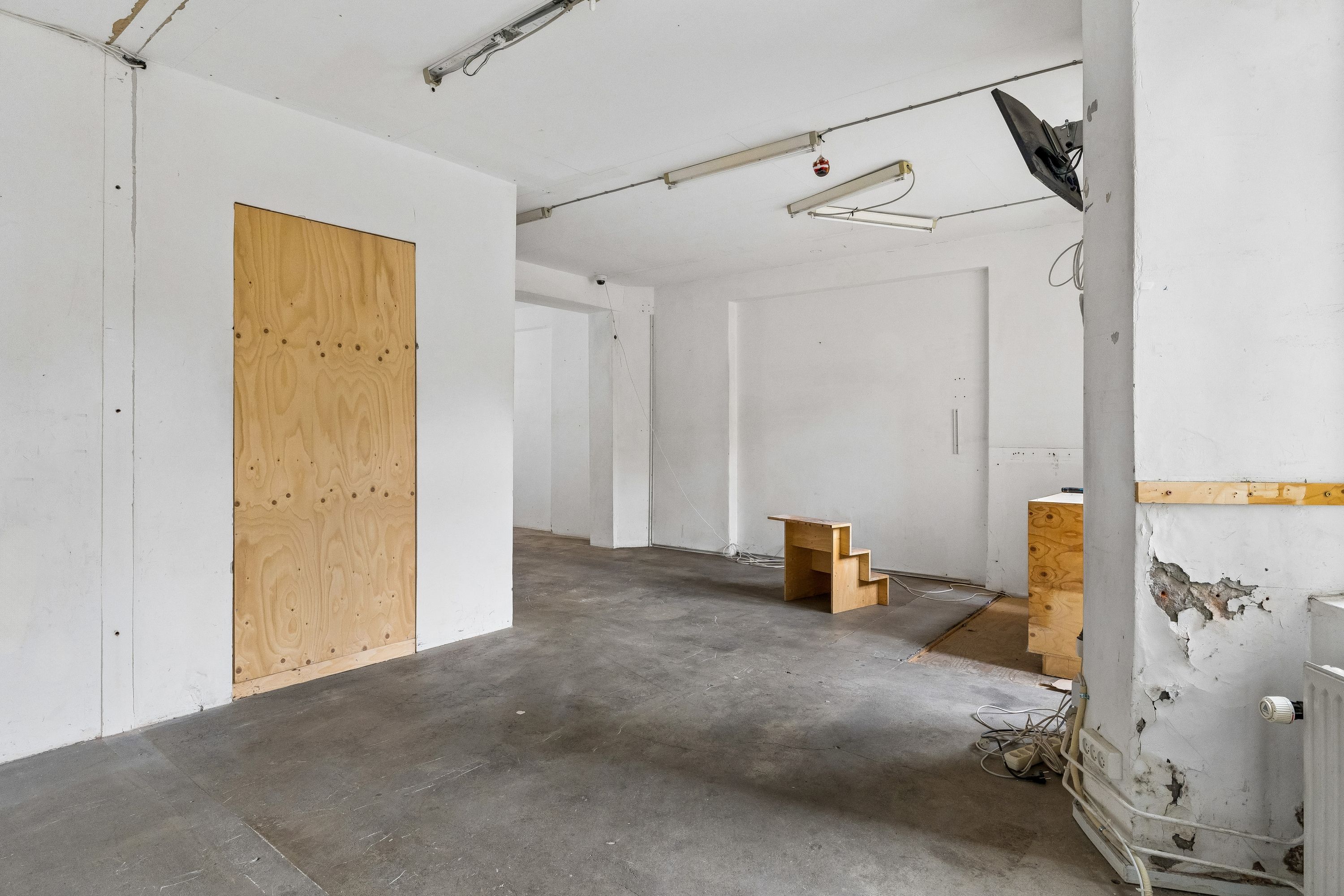 Rummelige lokaler til leje på Elmegade 13 med tomt loft og trægulv. Lokaler med åbent gulv og tomt loft i lejemål med trægulv