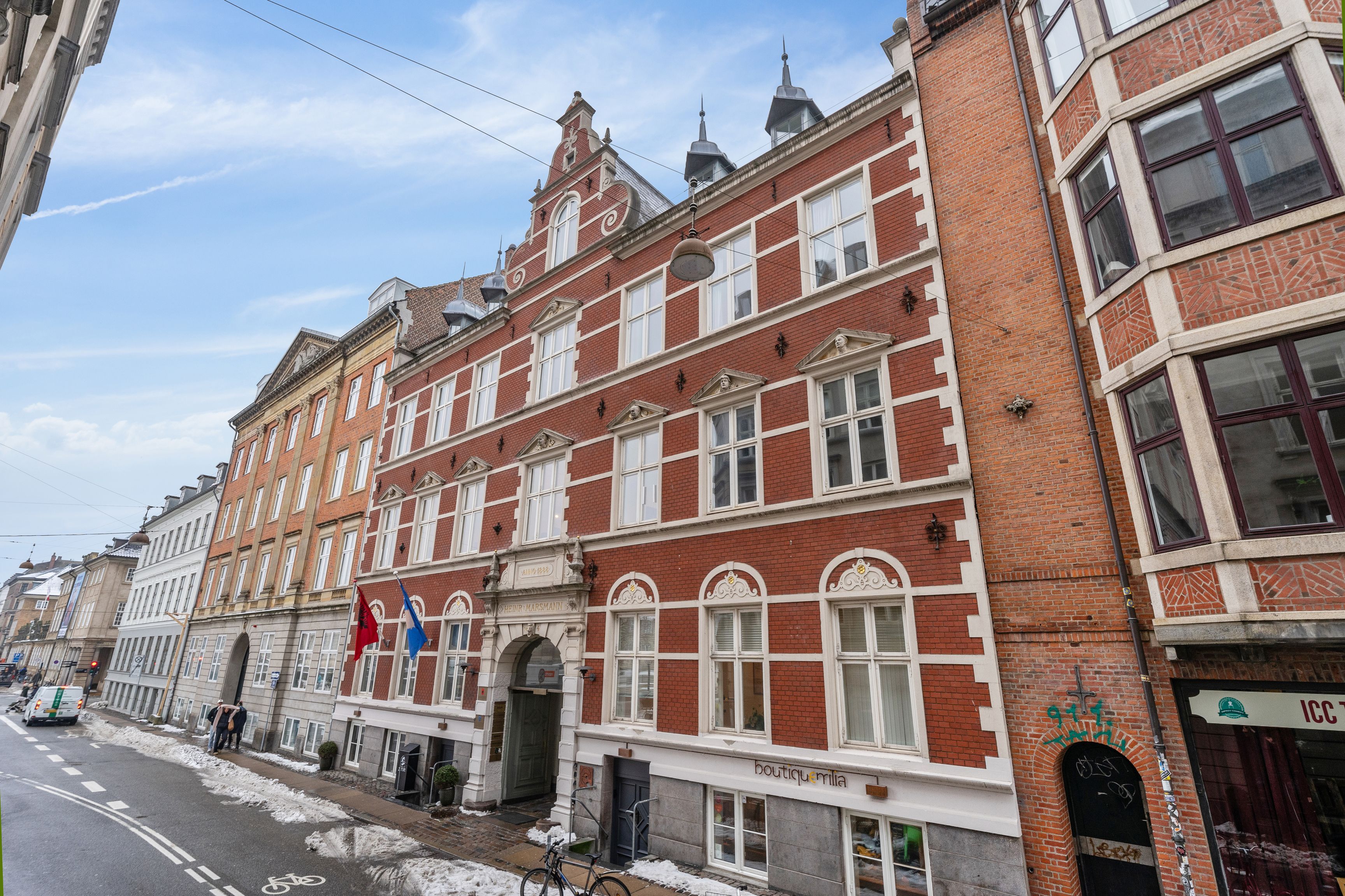 Frederiksholms Kanal 4B er et kontorlejemål på 5. sal med moderne design og store vinduer, to flag, og to cykler parkeret foran. Bygningen ligger i Københavns Indre By, og har en central beliggenhed.