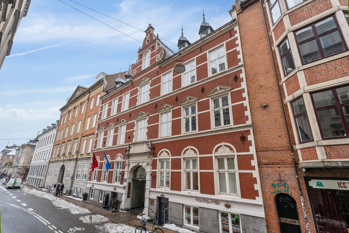 Frederiksholms Kanal 4B er et kontorlejemål på 5. sal med moderne design og store vinduer, to flag, og to cykler parkeret foran. Bygningen ligger i Københavns Indre By, og har en central beliggenhed.