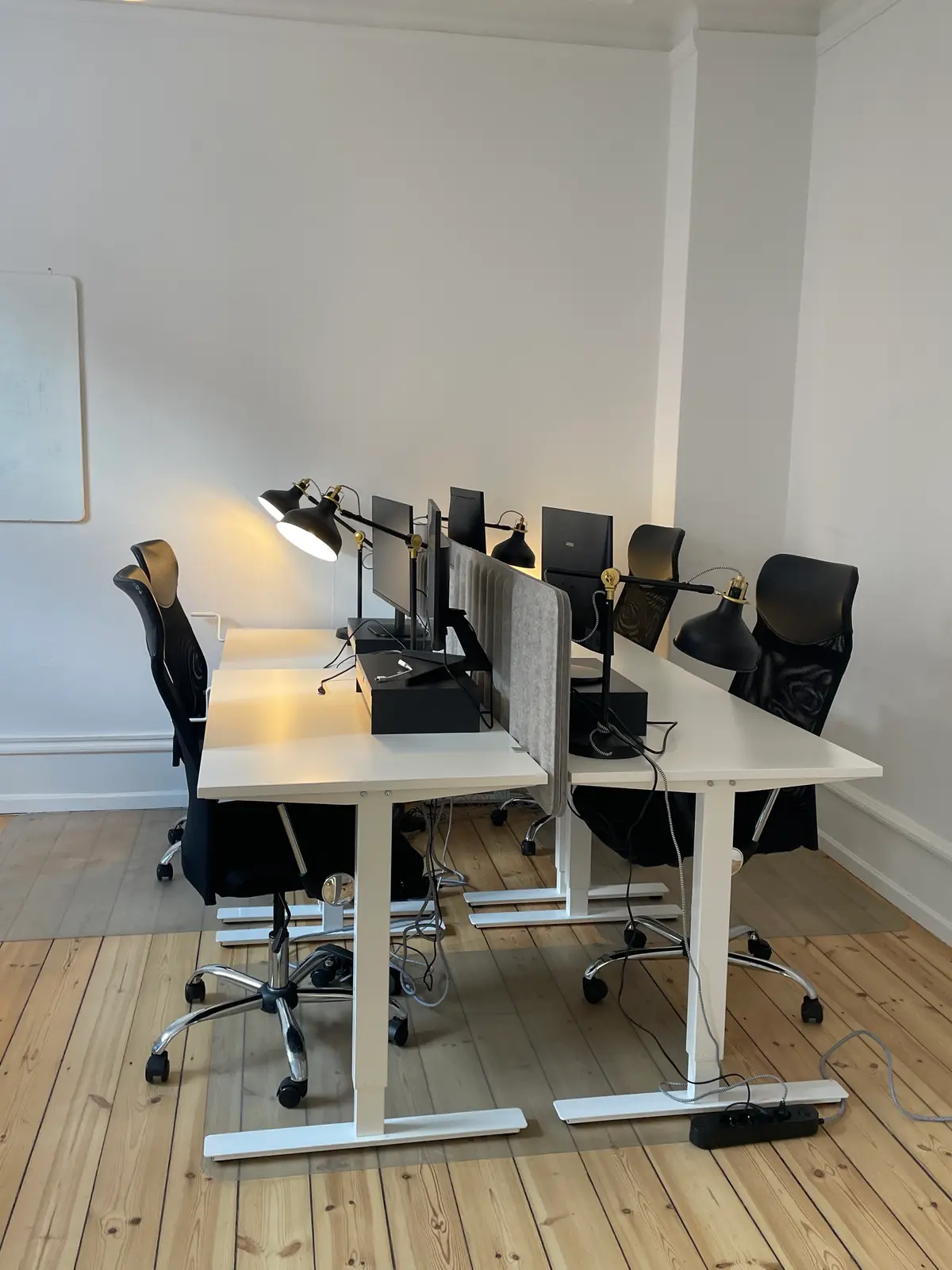 Kontorlokale med højt til loftet og store vinduer på Vesterbro med lyse gulve, moderne møbler og flere computere