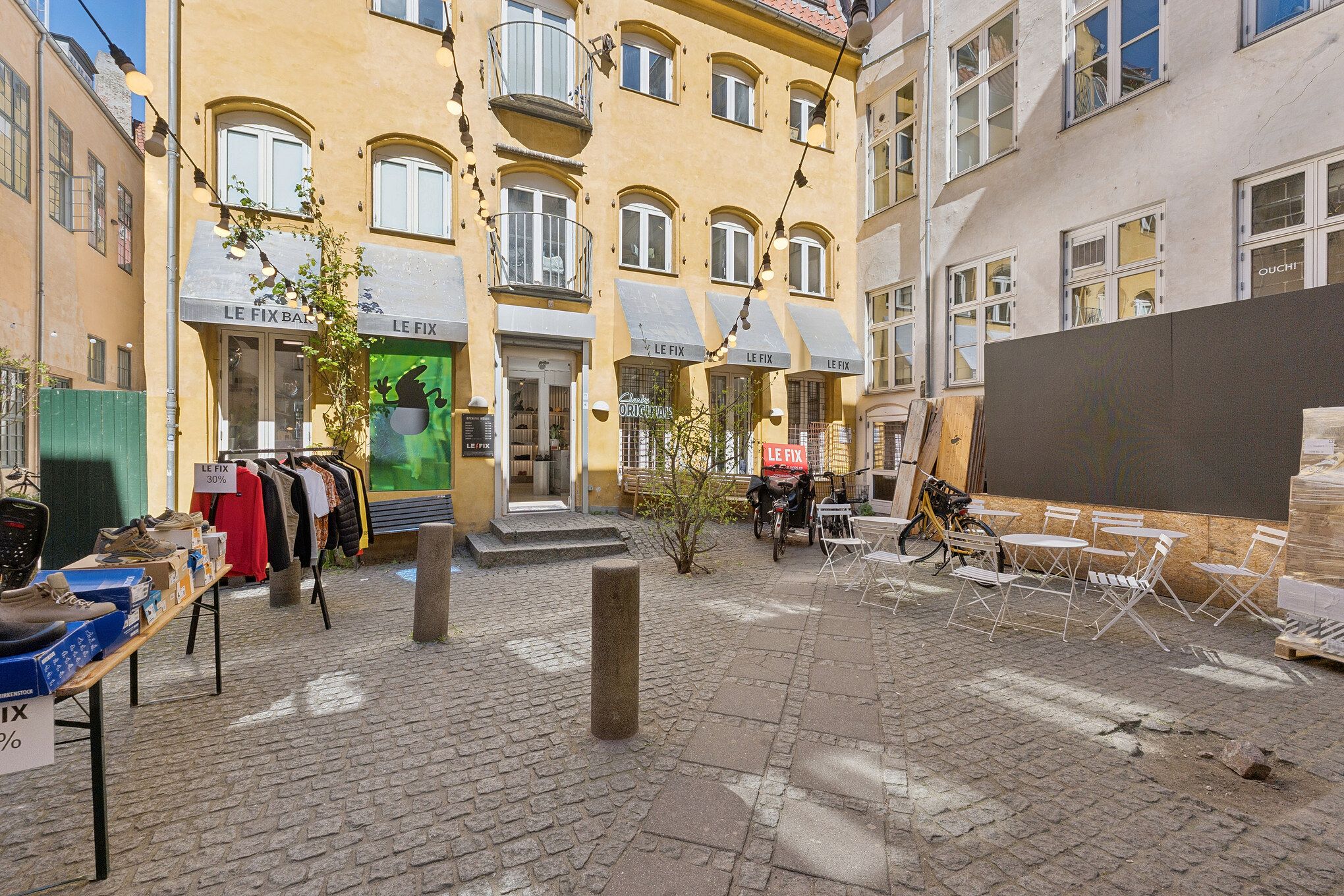 Solbelyst butikslejemål med møbler og tøj på Kronprinsensgade i Københavns Indre By, med solbelyste vinduer og terrasseborde