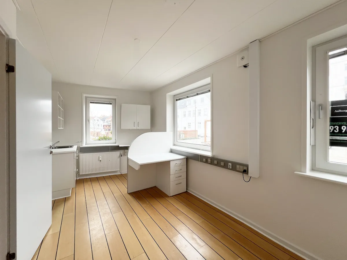 Lægeknik i velindrettet bygning med hvidt loft og gulv. Komplet med køkken og 2 vinduer med udsigt til gaden.