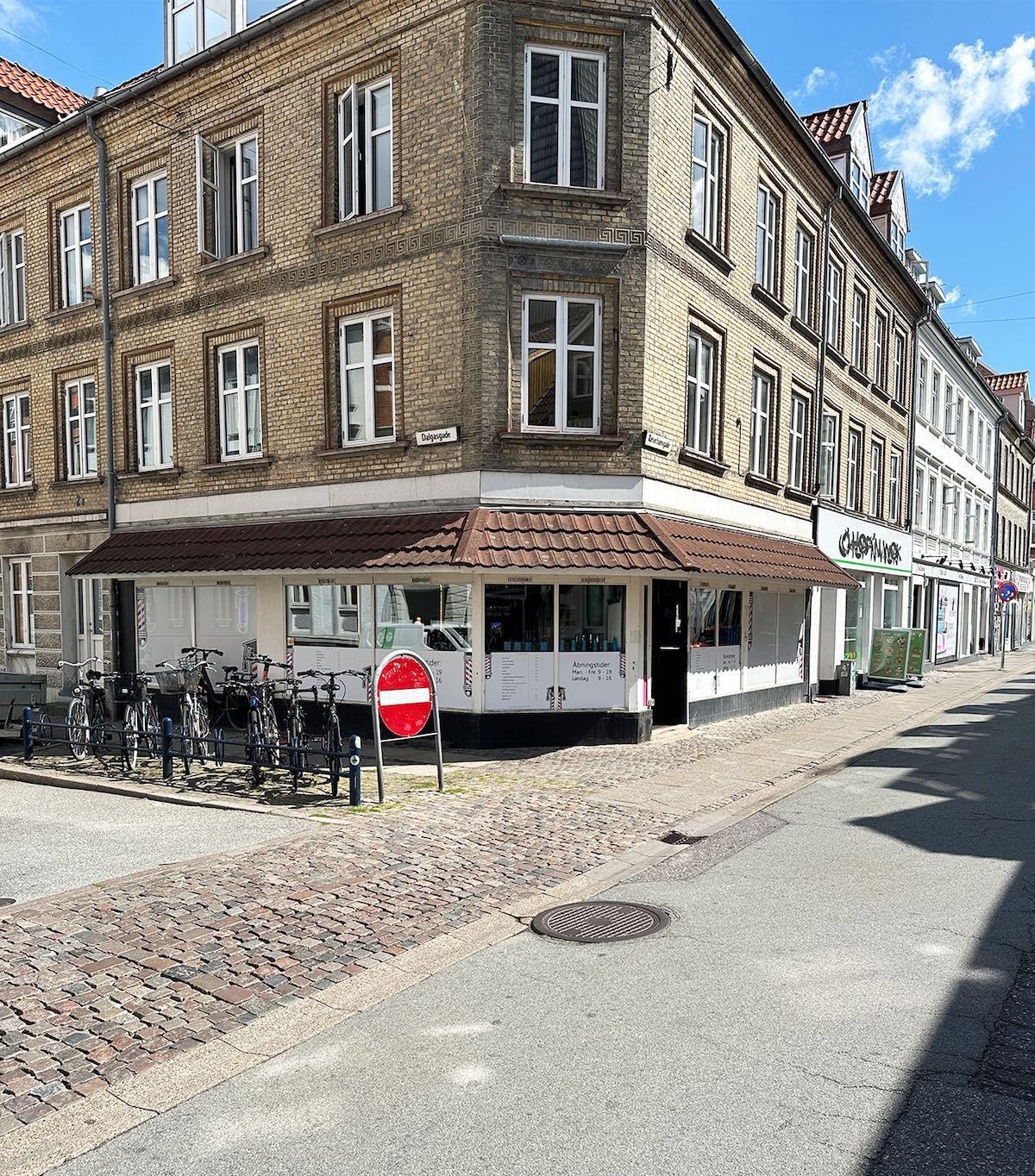 Butikslokaler med udsigt til Reberbansgade i Aalborg, med kæden "Chopphammer" og mange parkerede cykler udenfor