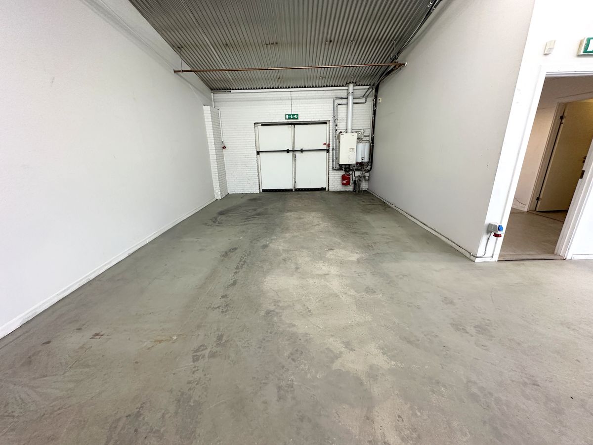 Store erhvervslejemål i Hjørring med to store garageporte og et rummeligt område med cementgulv