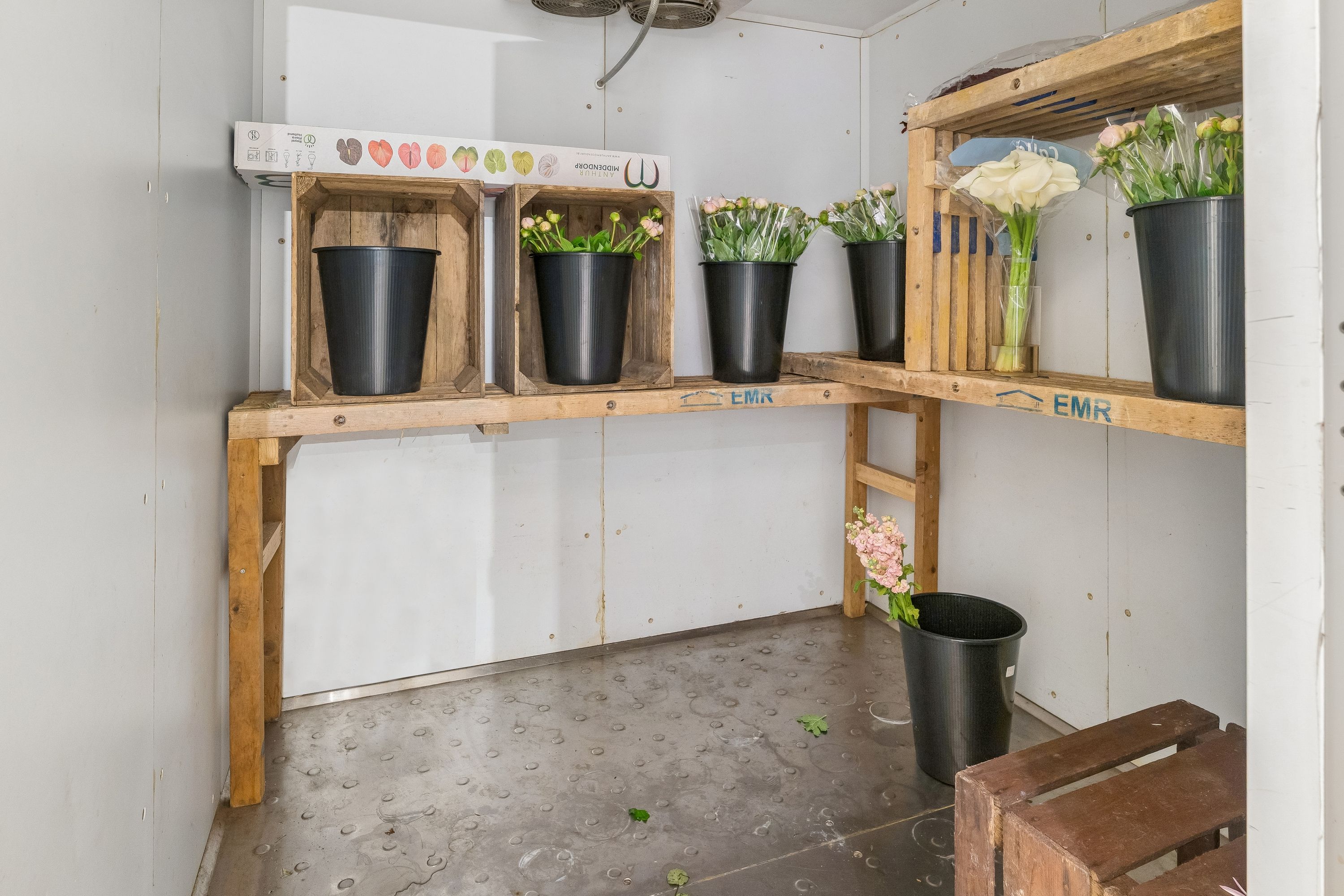 Lejlighed med blomsterbutik. Blomster i vase og kasserne med blomster og kartoner med blomster i butikken.