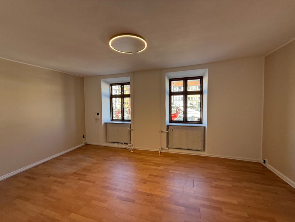 Kontor til leje med 115 m2 og flot udsyn til Nyhavn i København. To vinduer og to radiatorer. Trægulv og rundt lys på loftet.