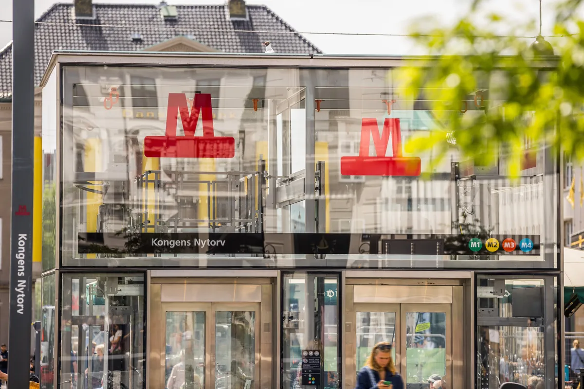 En moderne, luksuriøs metrostation er udstyret med røde bogstaver M i glas og teksten Kongens Nytorv på en sort skilt