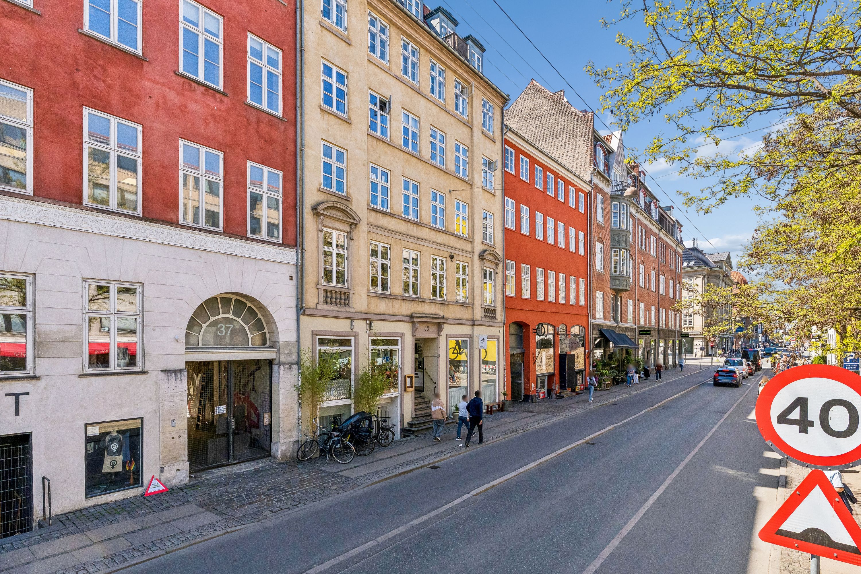 Butik til leje på Gothersgade 39, st. th, 1123 København K. Her er flere butikker med træplanter, en 40 km/t skilt og mennesker gående på gågaden