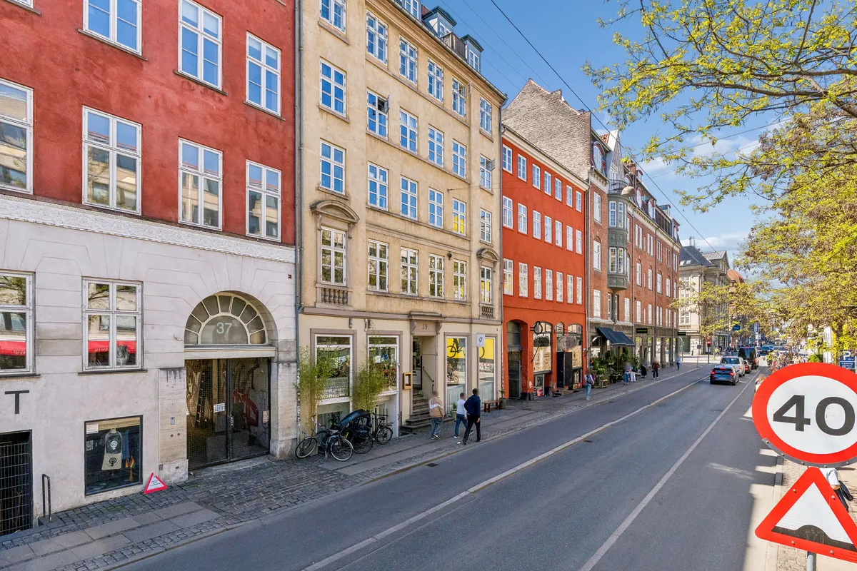 Butik til leje på Gothersgade 39, st. th, 1123 København K. Her er flere butikker med træplanter, en 40 km/t skilt og mennesker gående på gågaden