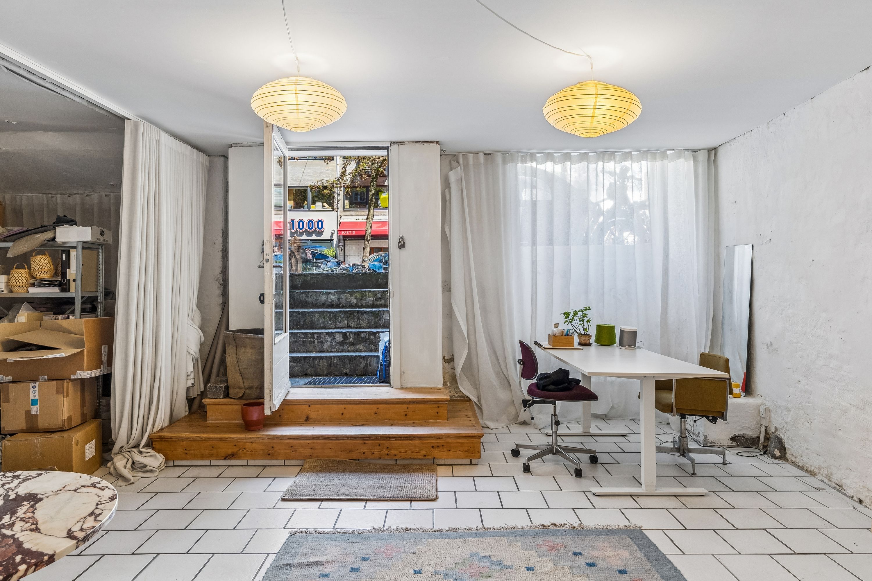 Lejlighed med indgang til Gothersgade 39, indret med hvidt loft, gulv og møbler, vinduer med hvide gardiner og trætrapper