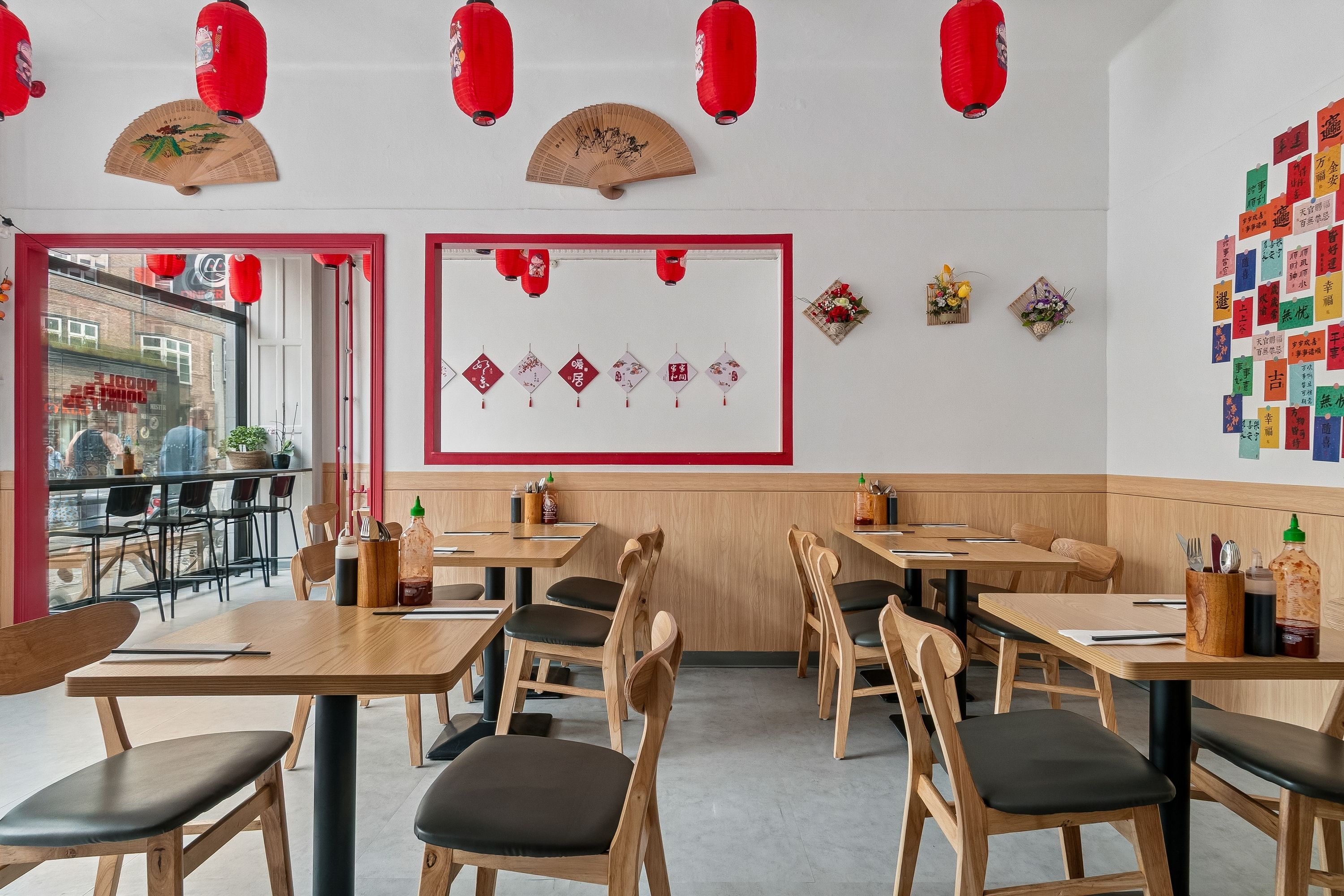 I en moderne restaurant med lyserøde kinesiske lanterner og lyserøde og hvide vægdekorationer serveres traditionelle kinesiske retter