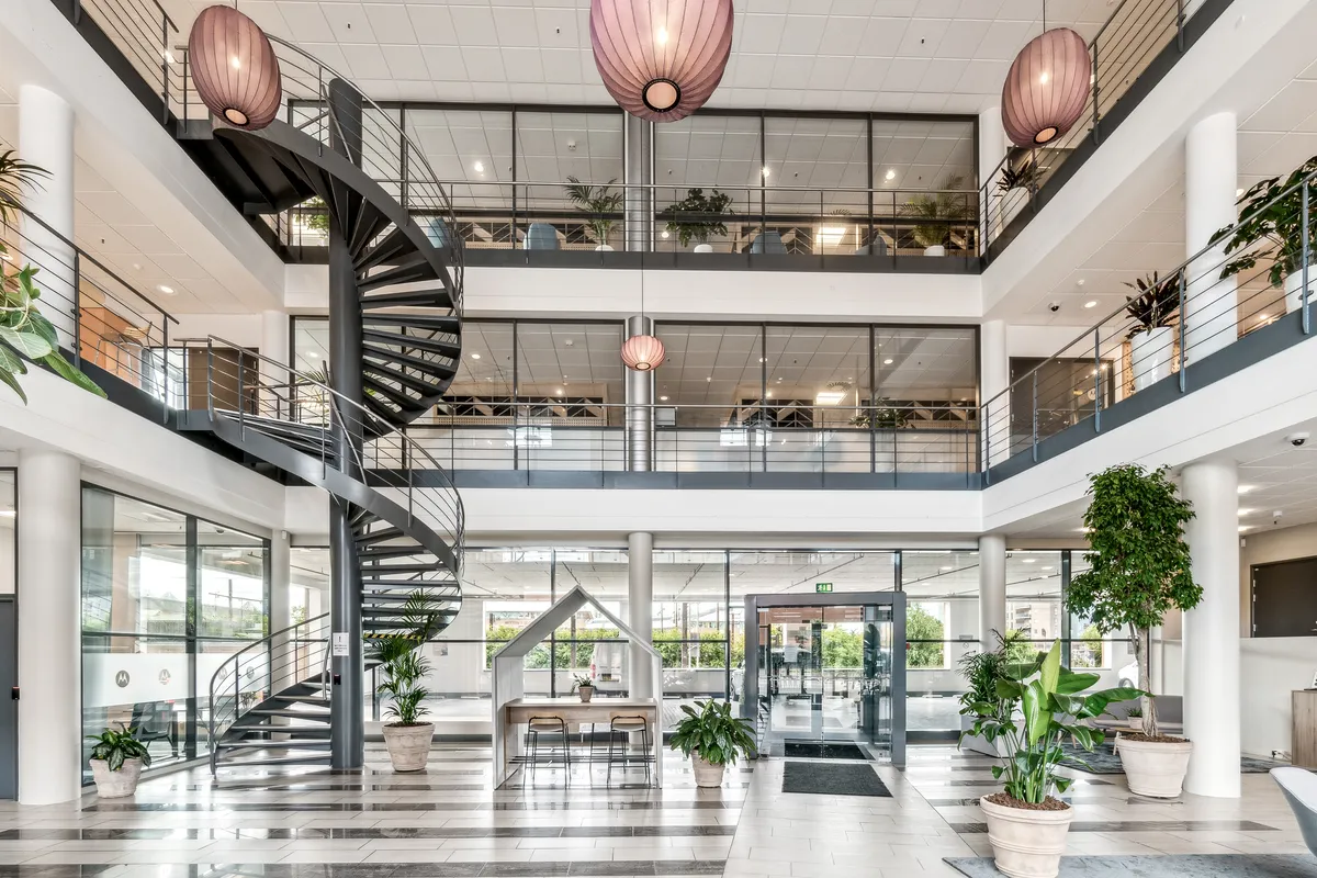 Kontorlokaler med udsigt til Glostrup Station, spiraltrappe og moderne møbler, masser af planteliv og store vinduer