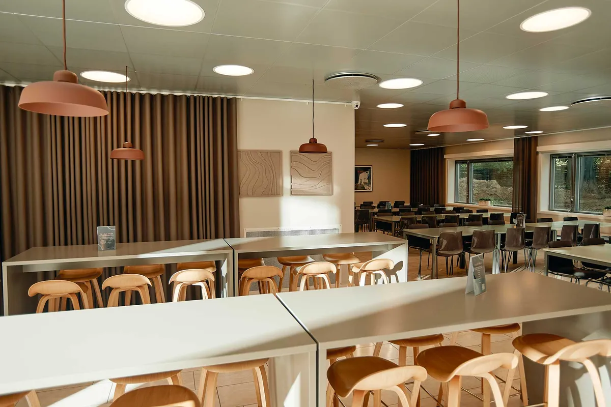 Åbent kontormiljø med bord, stole, kaffemaskiner og store vinduer til leje i serviceret erhvervsejendom i Kongens Lyngby