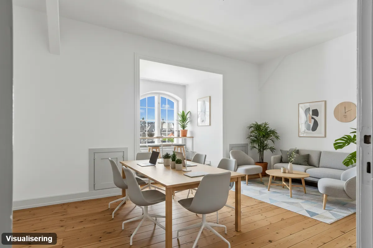 Kontor med møbler, sofa, plante og trægulv med en åben balkon med udsigt til byen