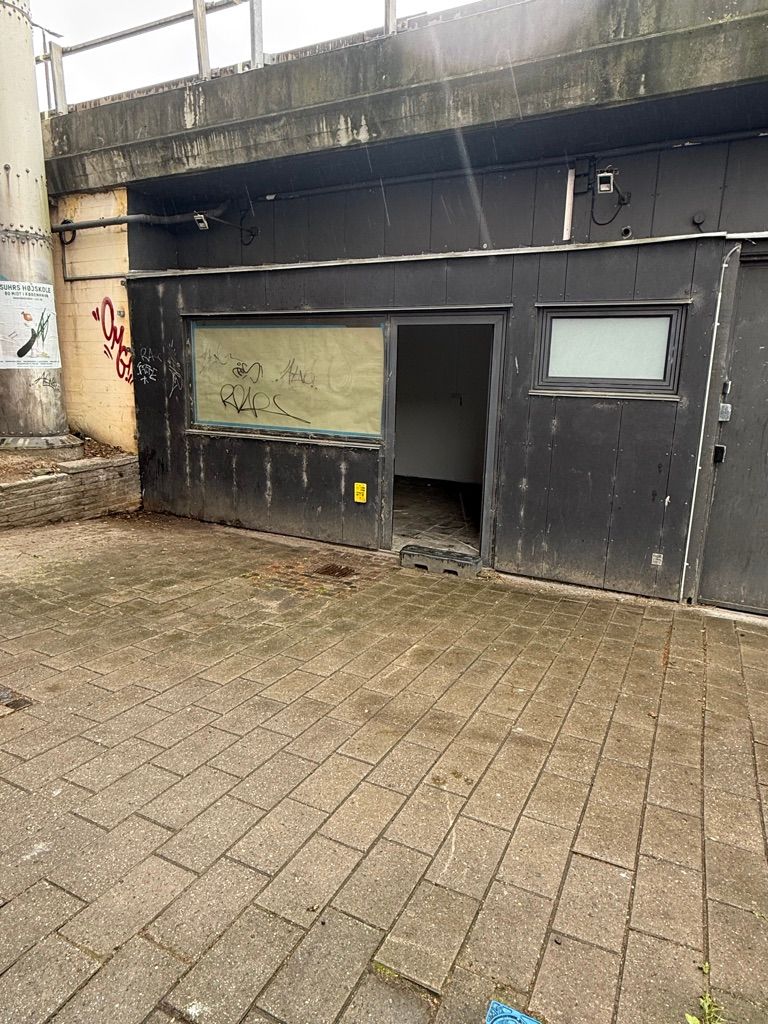 Kaffebar eller butik til leje på Jernbanepladsen 3A, Kongens Lyngby. Lejemålet er uden forsyning og har graffiti på væggene.