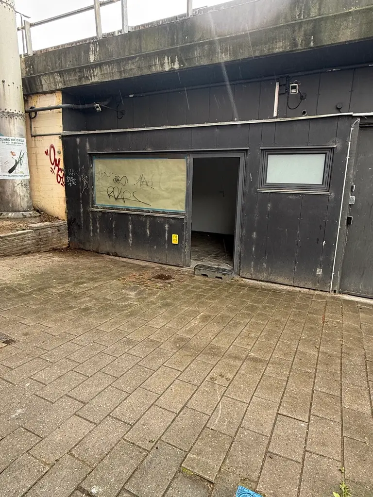 Kaffebar eller butik til leje på Jernbanepladsen 3A, Kongens Lyngby. Lejemålet er uden forsyning og har graffiti på væggene.