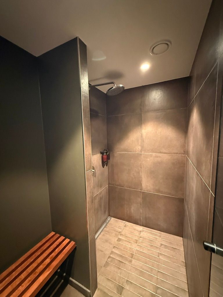 Det moderne fitness- og træningslokale på Jernbanepladsen 27 har et elegant brusebad og en træbænk til afslapning, alt i nærheden af Lyngby Station