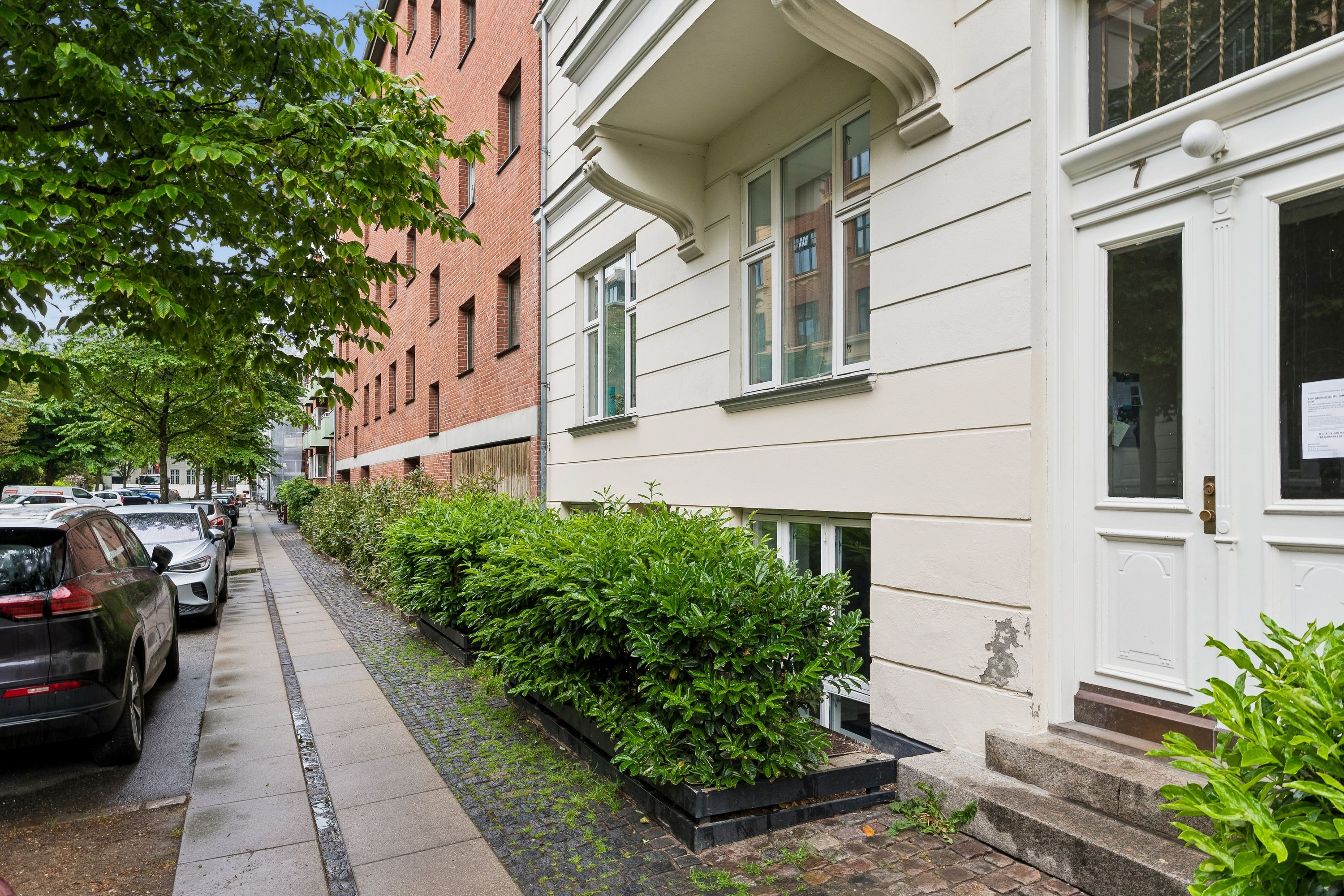 Kontor til leje på Harsdorffsvej 7, kl. tv, 1874 Frederiksberg C. Kontoret har hvide vægge, smukke buske og en dør med nummer syv