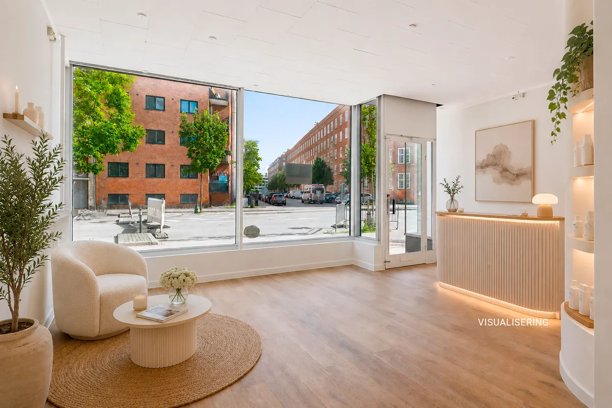 En elegant møbleret stue med store glasvinduer og udsigt til byen. En hvid sofa, et trægulv, et højt bord og en plante i en stor gryde.