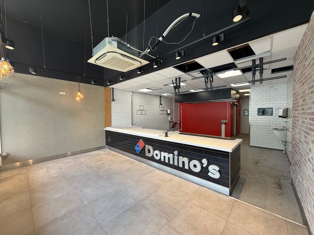 Take away-lejemål i Kongens Lyngby med Domino's-logo på disken og rødt køleskab