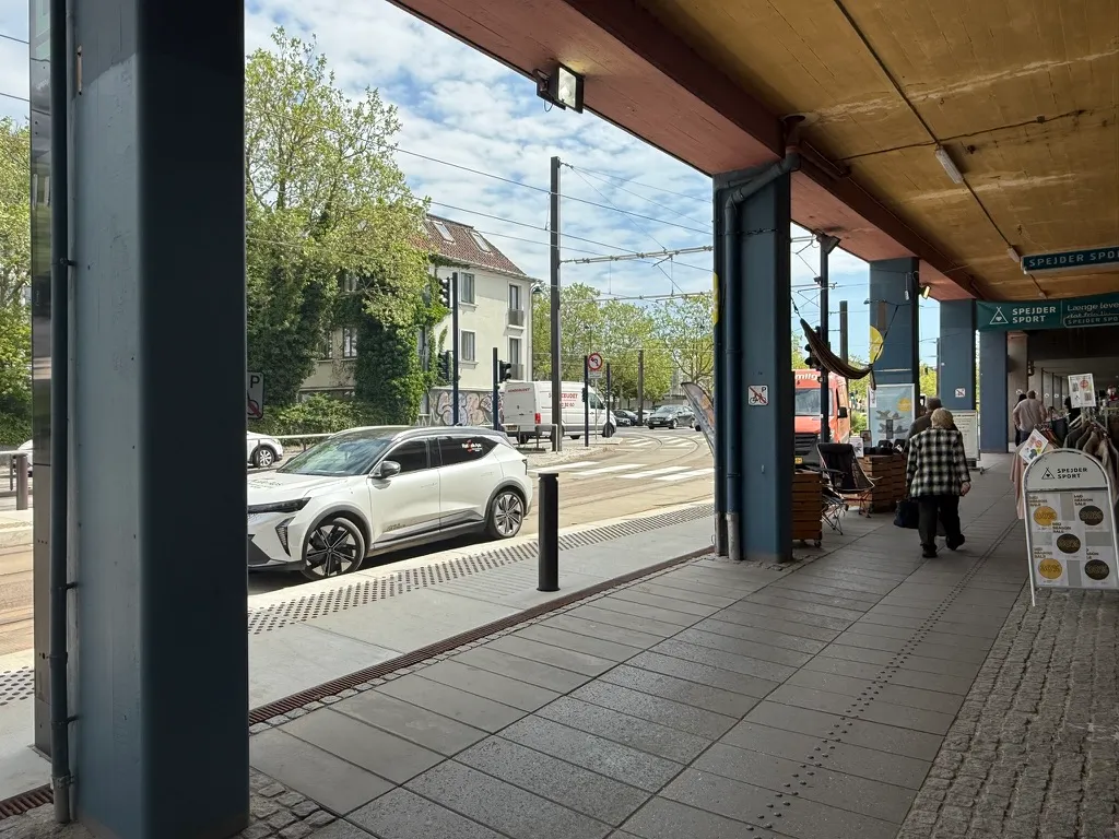 Take-away-lejemål med udgang mod Jernbanepladsen 61 i Kongens Lyngby med biler, gågade og spænder med tøj