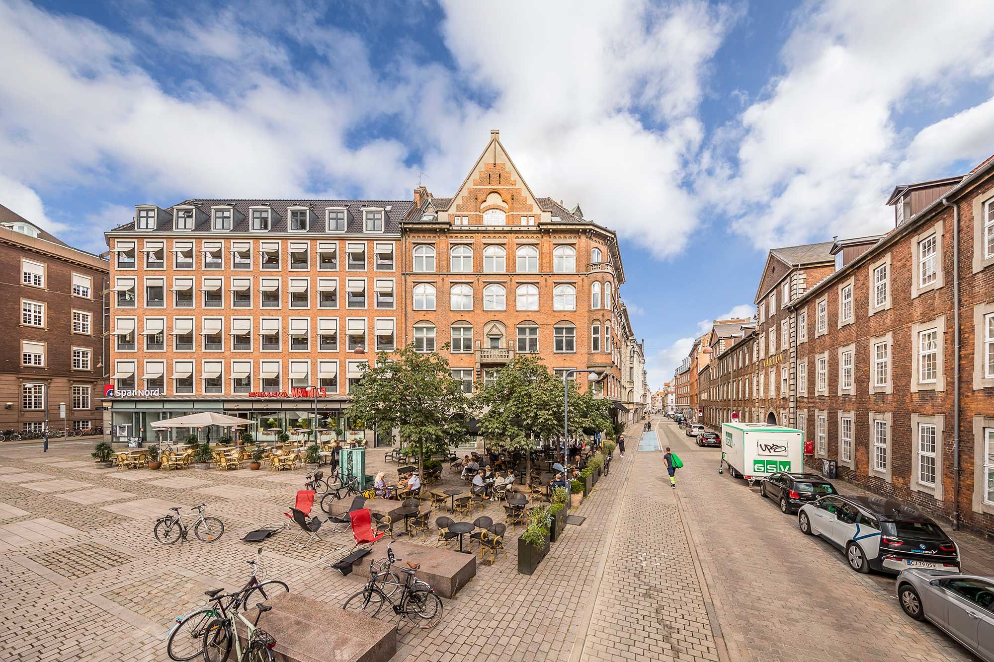 Dansk kontorfællesskab i klassisk københavnsk bygning med udsigt over byens tårne og tage