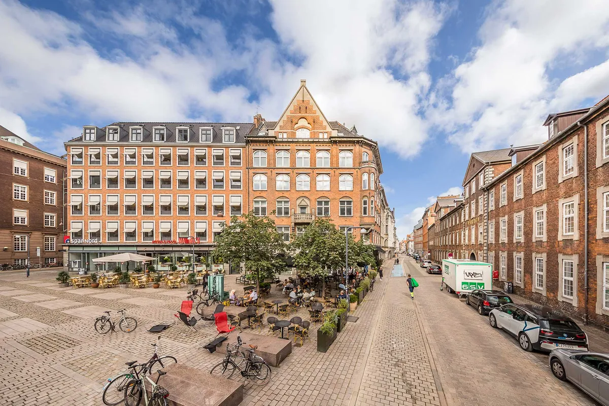 Dansk kontorfællesskab i klassisk københavnsk bygning med udsigt over byens tårne og tage