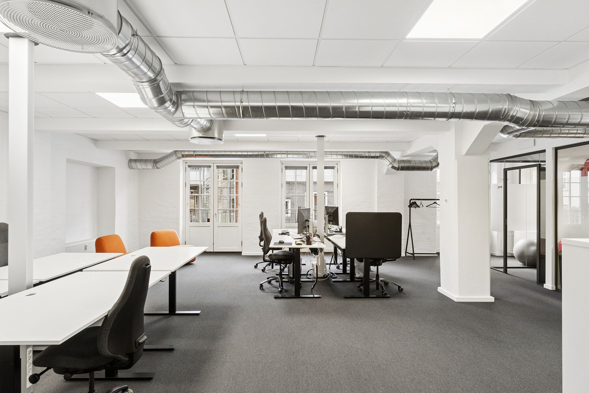 Kontor med moderne møbler, lyse lofter og store vinduer med udsigt til gaden og terrassen. Værelser med ventilationsrør og højt gulv, tæt ved kontorfællesskaber og fælles faciliteter.
