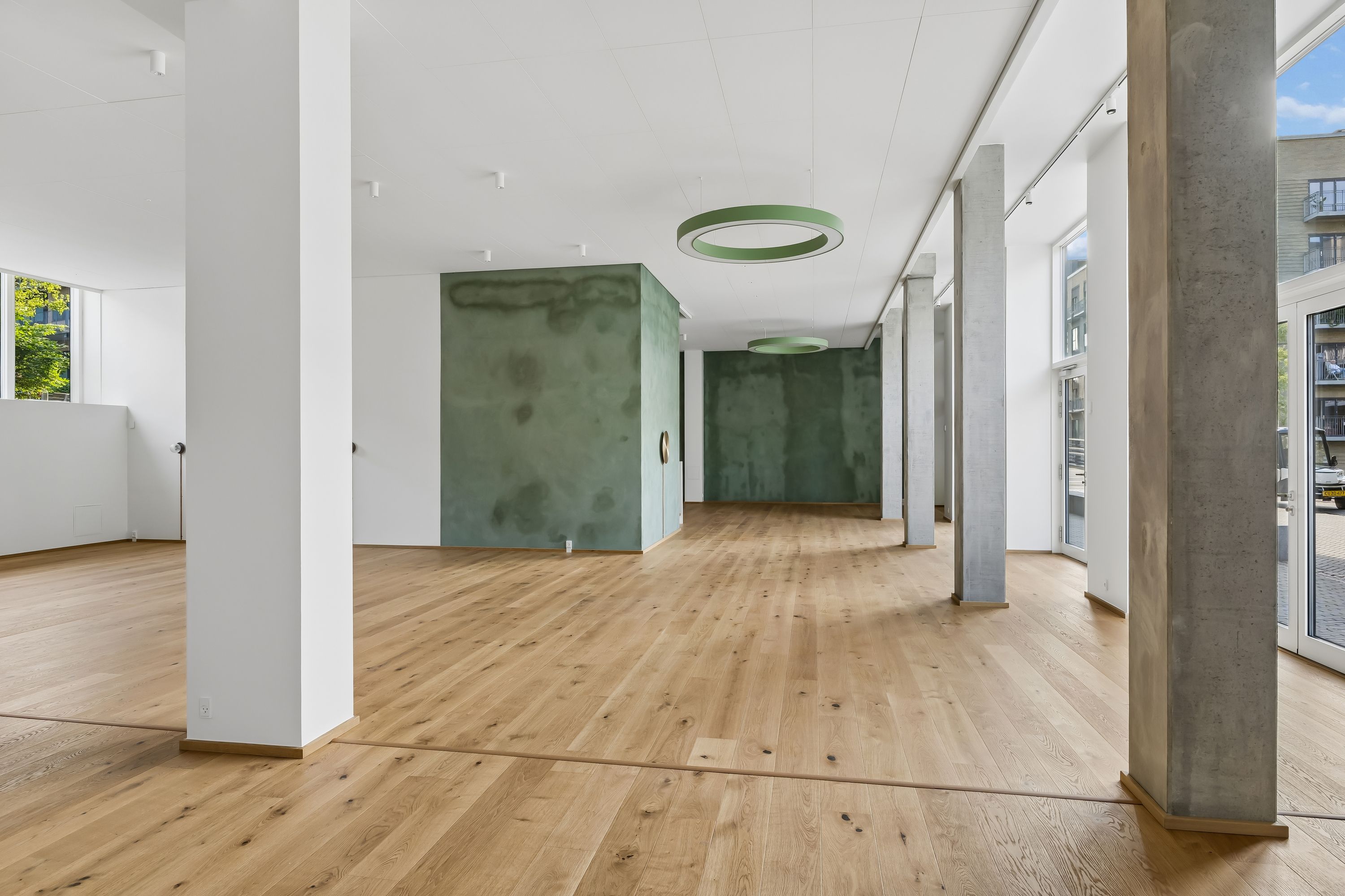 Restaurant med moderne design og massiv trægulv, store vinduer, lyse hvide vægge og grønne vægmalerier