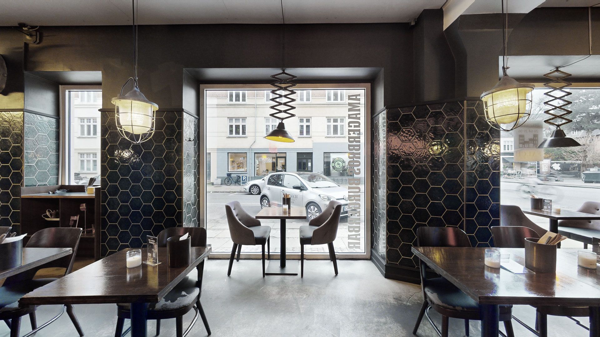 Restaurant med lyse lamper og bord med forretninger udenfor, Amagerbrogade 145, 2300 København S, lukket dør og glasvinduer