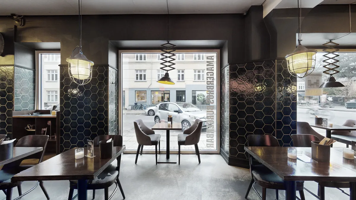 Restaurant med lyse lamper og bord med forretninger udenfor, Amagerbrogade 145, 2300 København S, lukket dør og glasvinduer