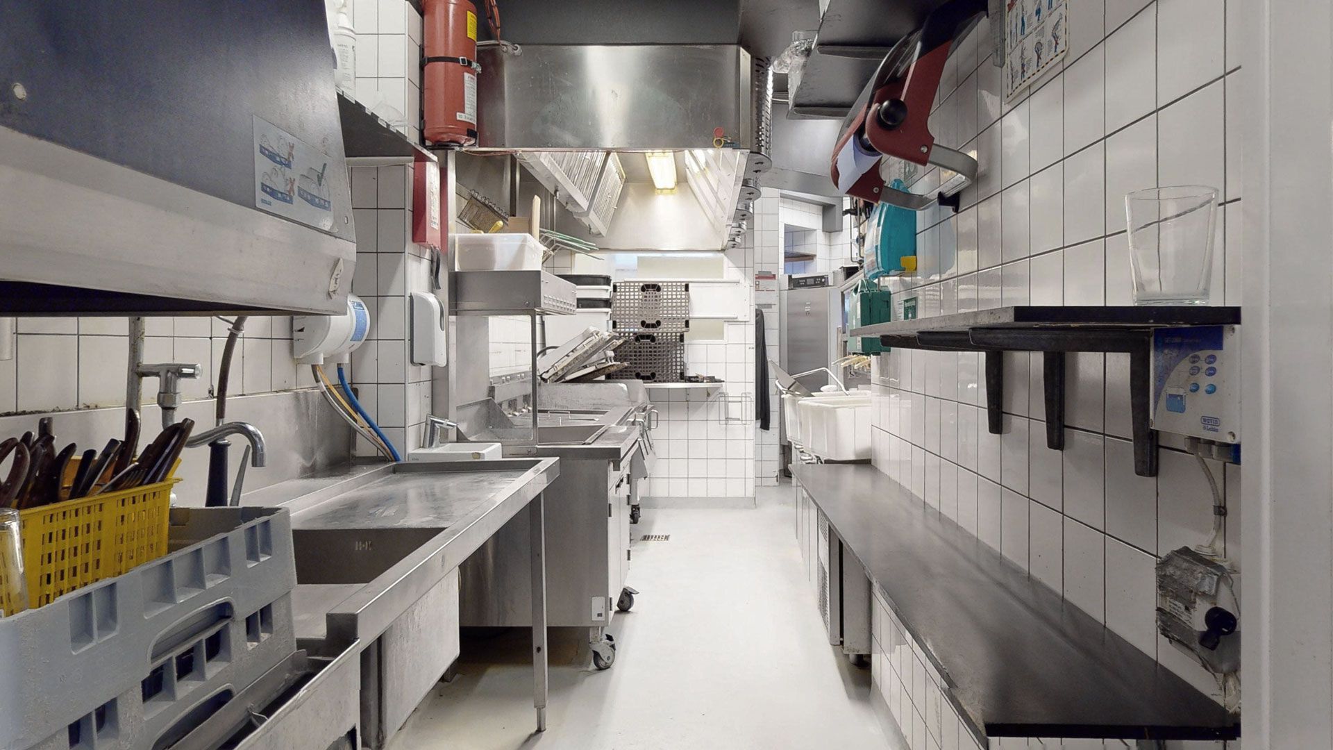Rummeligt kommercielt køkken med flere renseri, to vasker og en vaskemaskine i en moderne og veludstyret restaurantlejemål på Amagerbrogade
