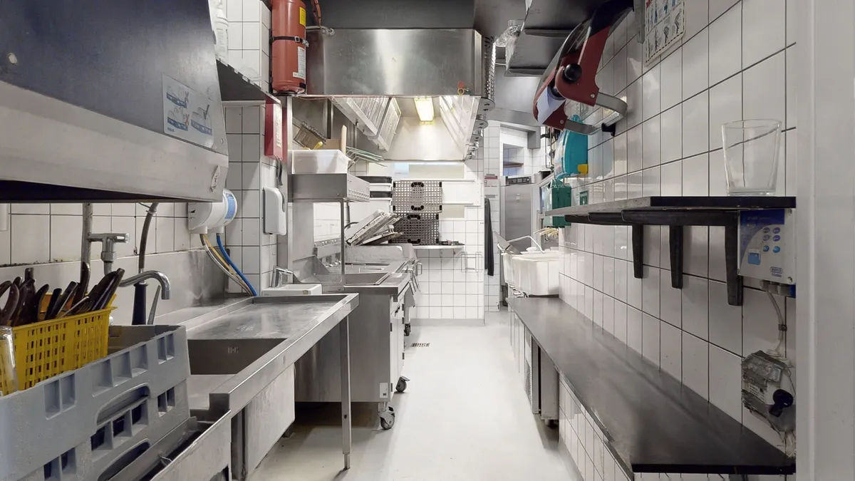 Rummeligt kommercielt køkken med flere renseri, to vasker og en vaskemaskine i en moderne og veludstyret restaurantlejemål på Amagerbrogade