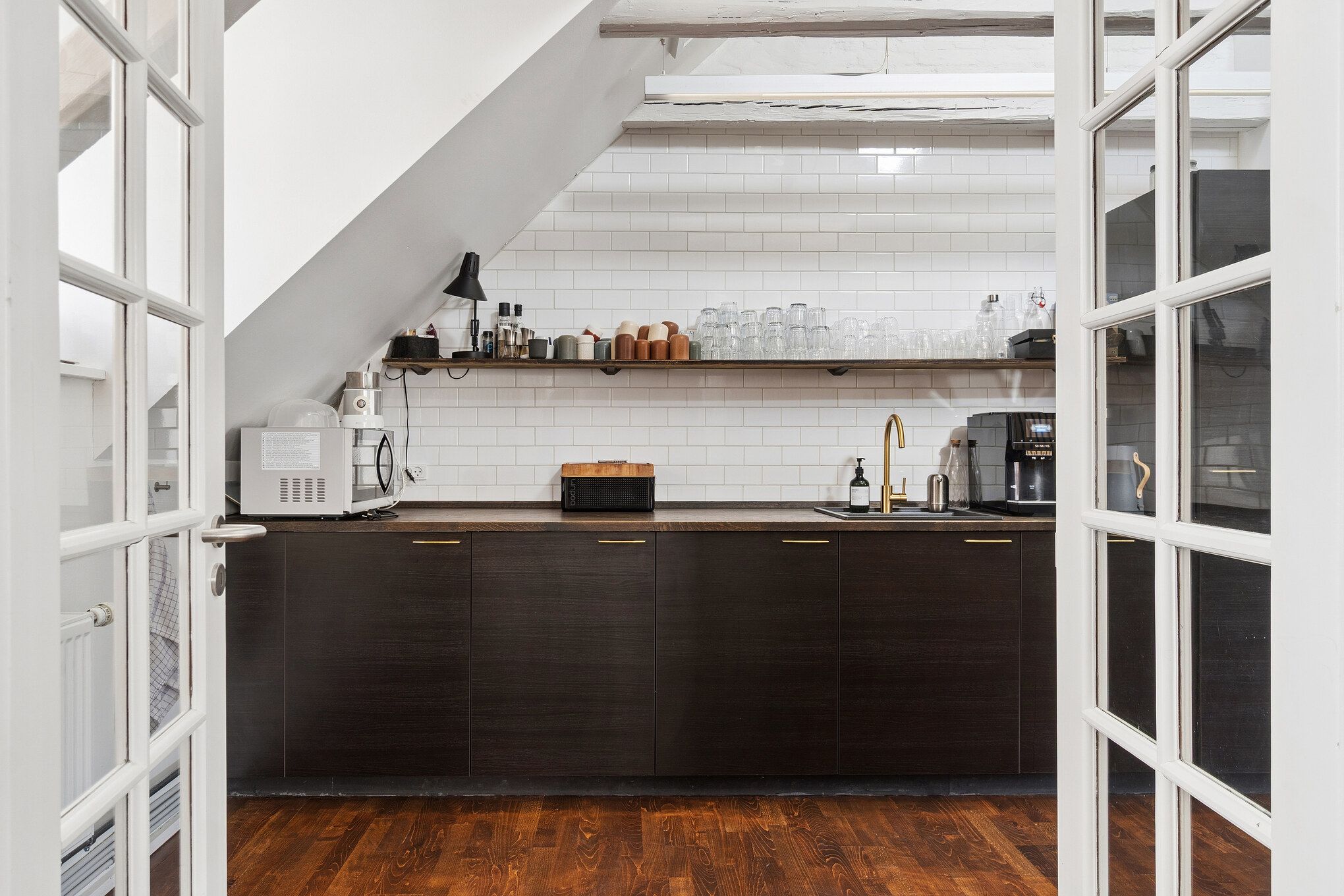 Moderne køkken med træklæg og hvidt loft, hvid keramisk fliser, mørke skabe, skarpe hjørner, lyse vinduer og lysekroner, funktionel og minimalistisk design