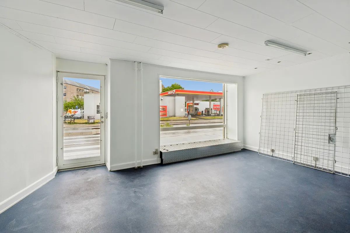 Et lyst erhvervslejemål med store udstillingsruder og moderne indretning, hvor der er store facadevinduer til vejen