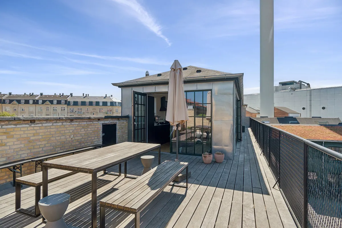 Terrasse med bord og bænke, paraply og planter i lyse, moderne og indbydende kontorområde på Glentevej 47, 1. sal, København