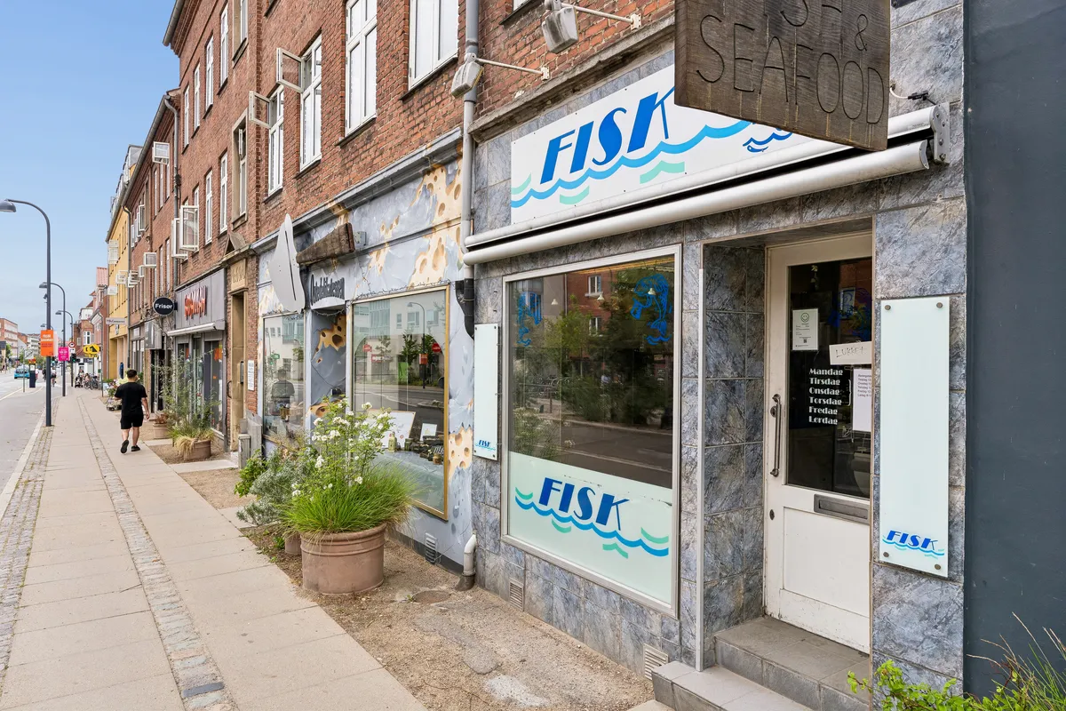 En butik med FISK-skilt og vindue i Søborg Hovedgade, med udstillingsruder og grønne planter foran