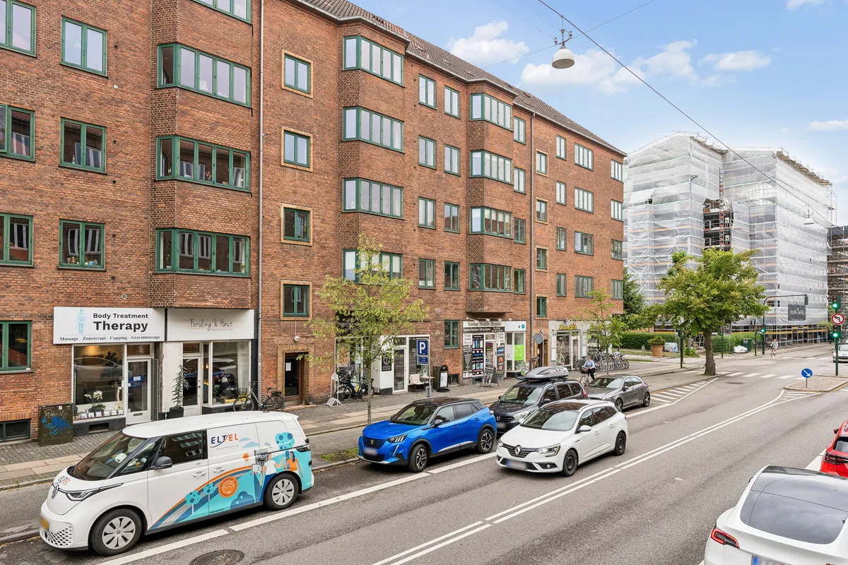 Erhvervslejemål i Frederiksberg med Body Treatment Therapy og Forsling & Høst butikslokaler. Biler parkeret og gående forbi.