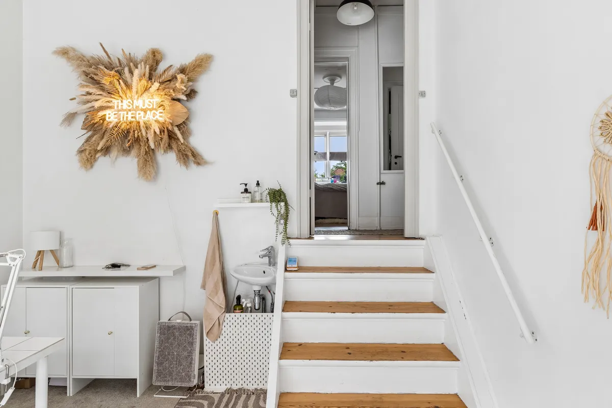 Nyrenoveret lokale med hvidt loft og vægge, loftslampe og håndtag. Køkken med hvidt bord og høj skab, og sammen med stol og lysekrone