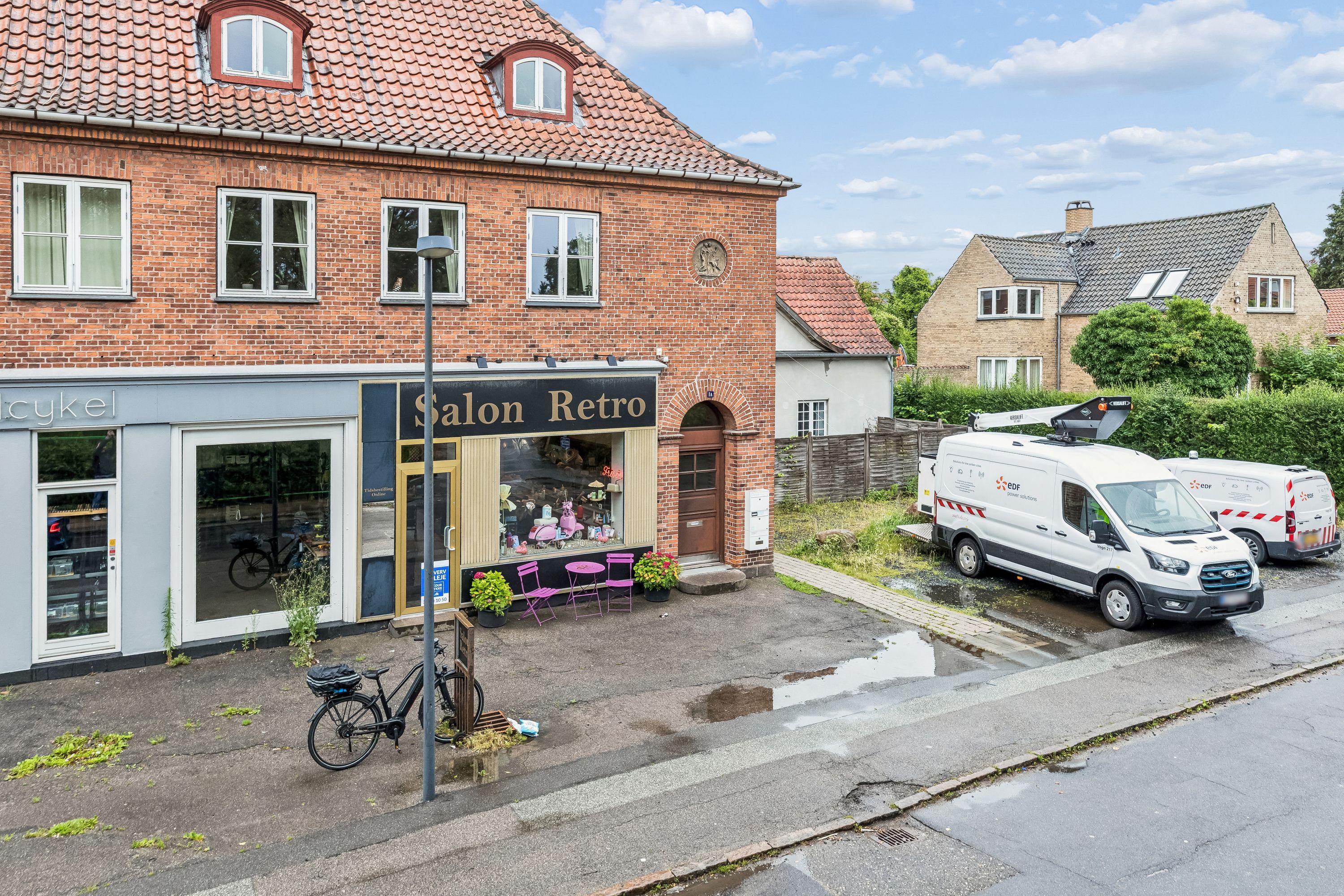 Butik med navnet Salon Retro, to servicevognlæsser og en cykelparkeret foran indgangen