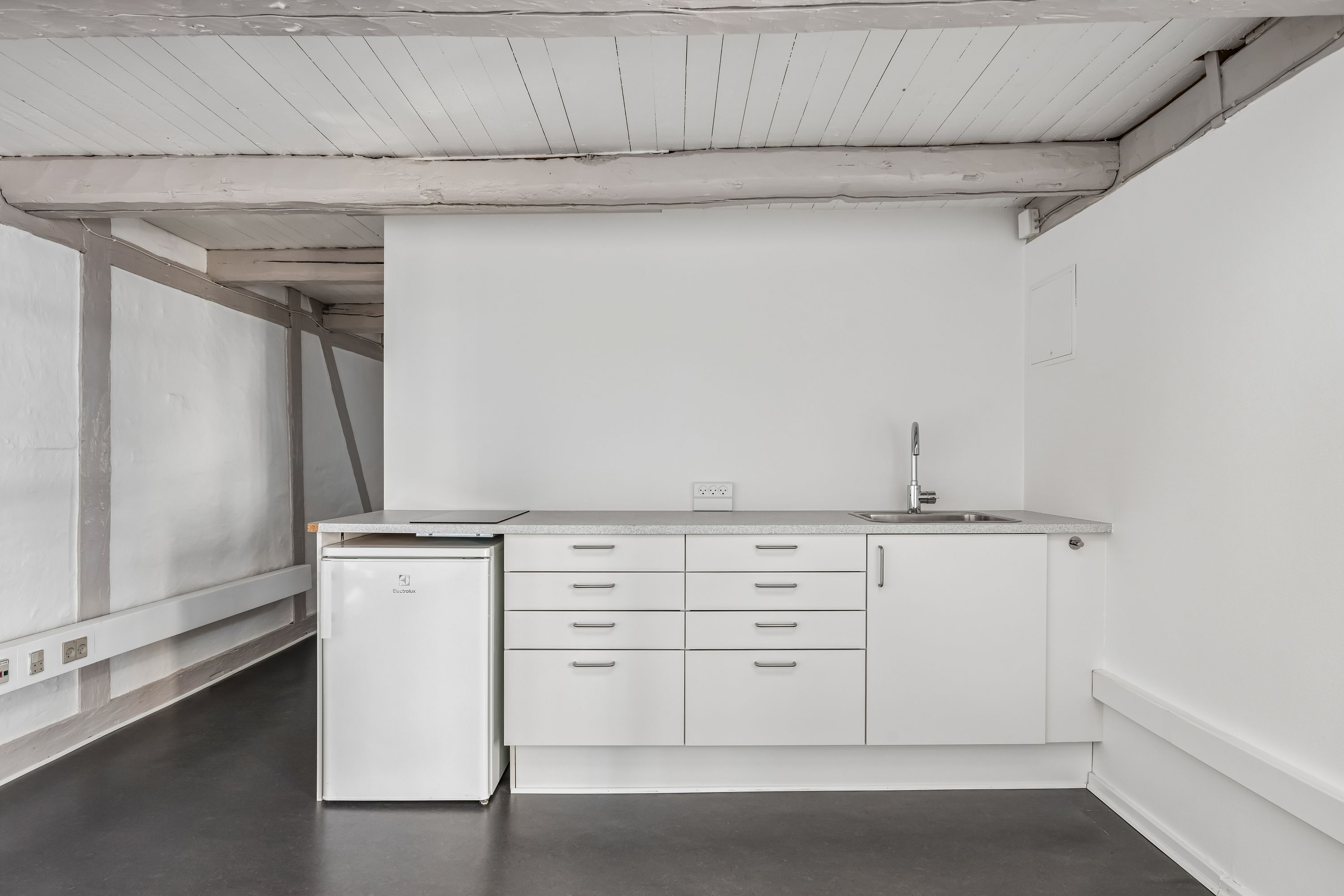 Moderne, minimalistisk kontor med hvidt køkken og køleskab, lyse loftsbjælker og tæt på Københavns centrum