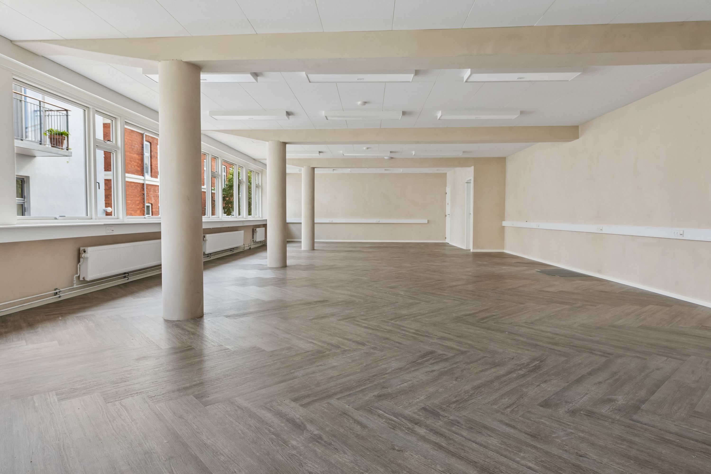 Kontor til leje på Dronning Olgas Vej med lys, lysegule vægge og moderne hvide lofter. Røgfrie, lyse vinduer med store udsigtsvinkler og luksuriøs trægulv.