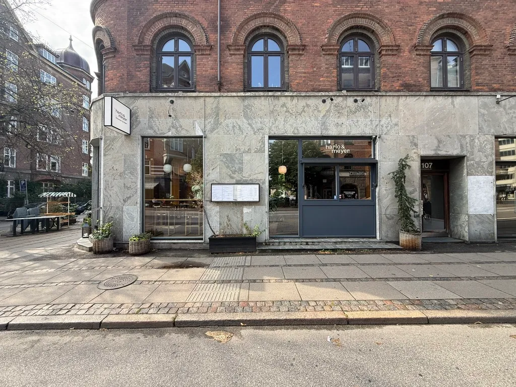 Bageri og delikatesse med moderne design, hvor grønne plantager og lyse lamper skaber hyggeligt indtryk på Gammel Kongevej 107, Frederiksberg