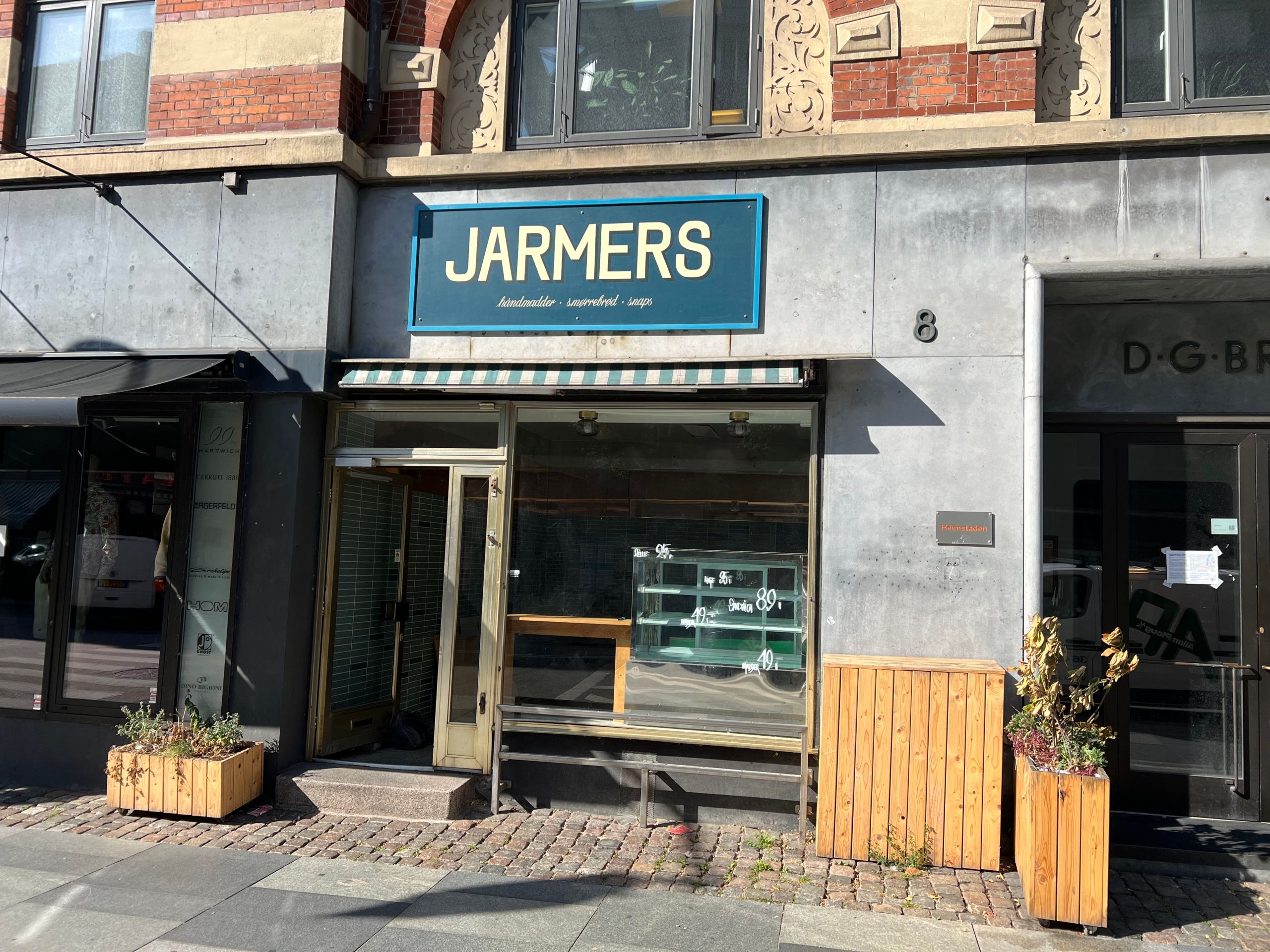 Lejlighed til leje på Vester Voldgade 8 i København med gårdhave, møbleret og i nærheden af D-G-B. Lokaler med vinduer og udsigt til gaden og en stol ved indgangen.