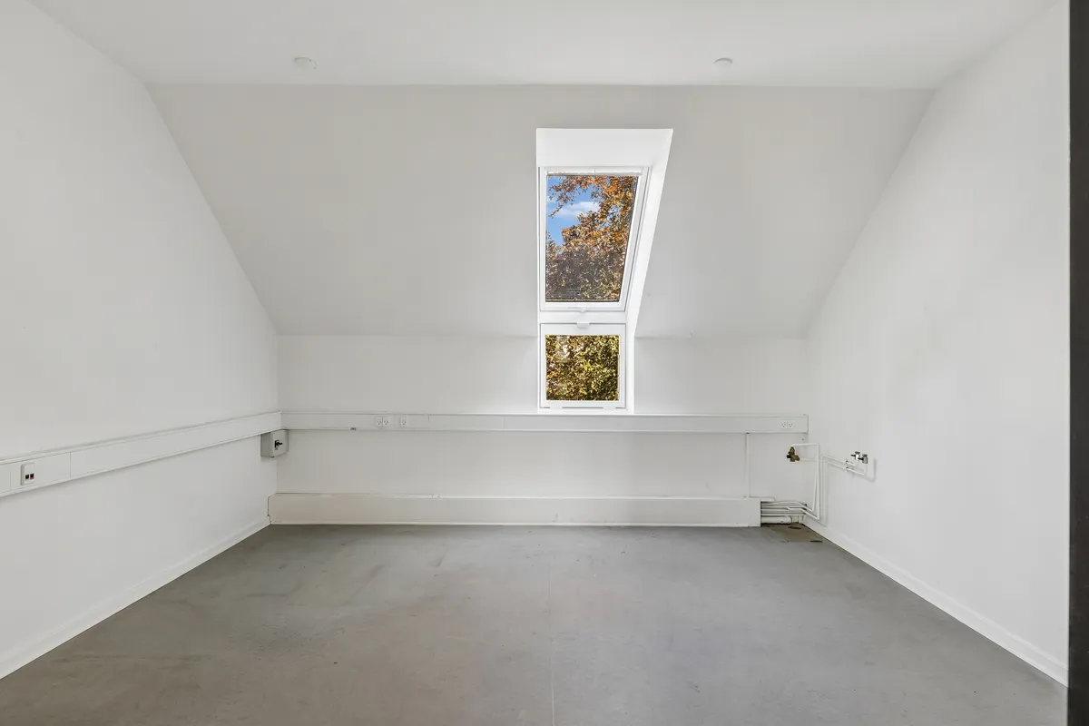 Lyst og veldisponeret erhvervslejemål på 160 m² med to loftsvinduer og lyse lofter samt moderne hvide vægge og gulv